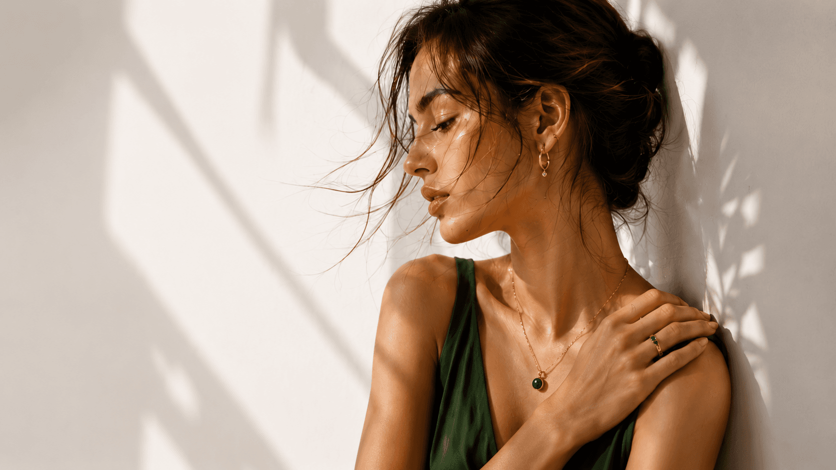 Model wearing Aniqas demi-fine gold jewellery in soft daylight